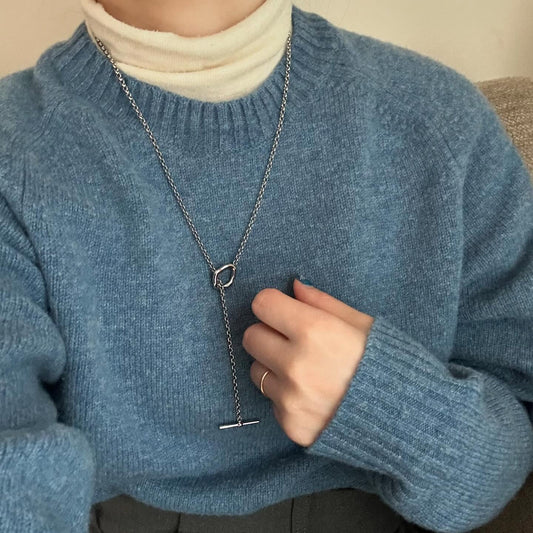 ゆるトップスに映える、さりげない縦ラインネックレスのきらめき。