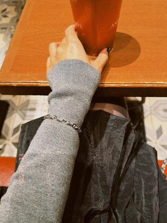 冬のスタイルに映える、さりげないシルバーブレスレットの存在感。