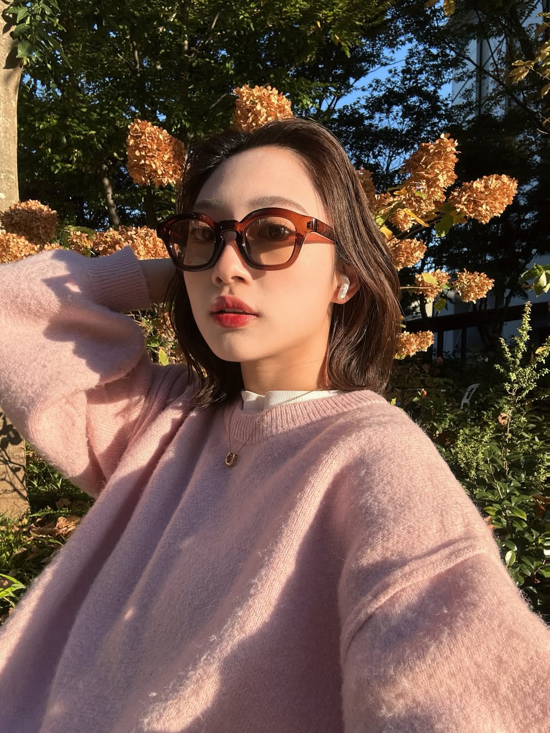 やわらかなニットに寄り添う、ホースシューネックレスのさりげない輝き。