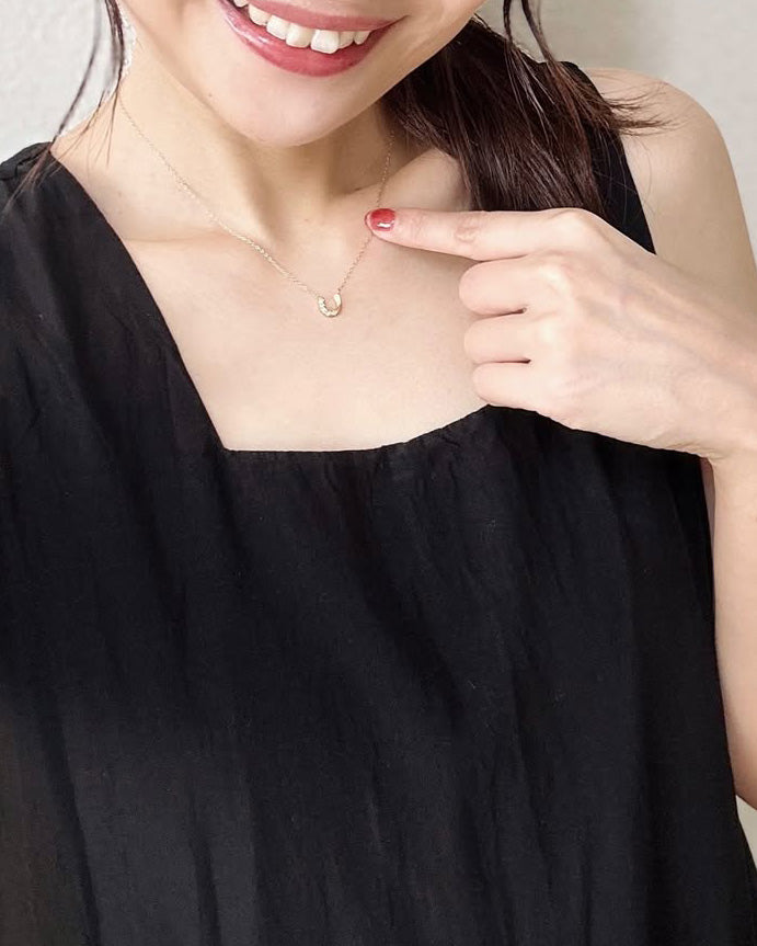 首元に寄り添うホースシューネックレス