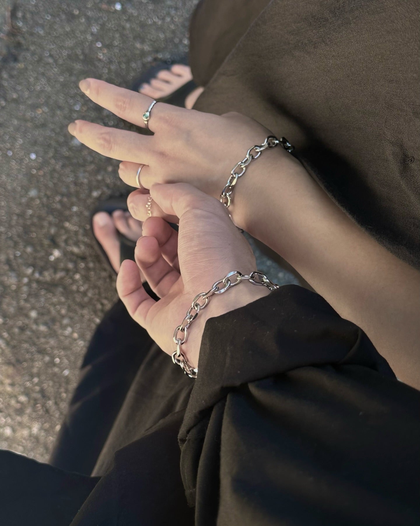 ペアで楽しむシルバーのチェーンブレスレットとリングのコーディネート