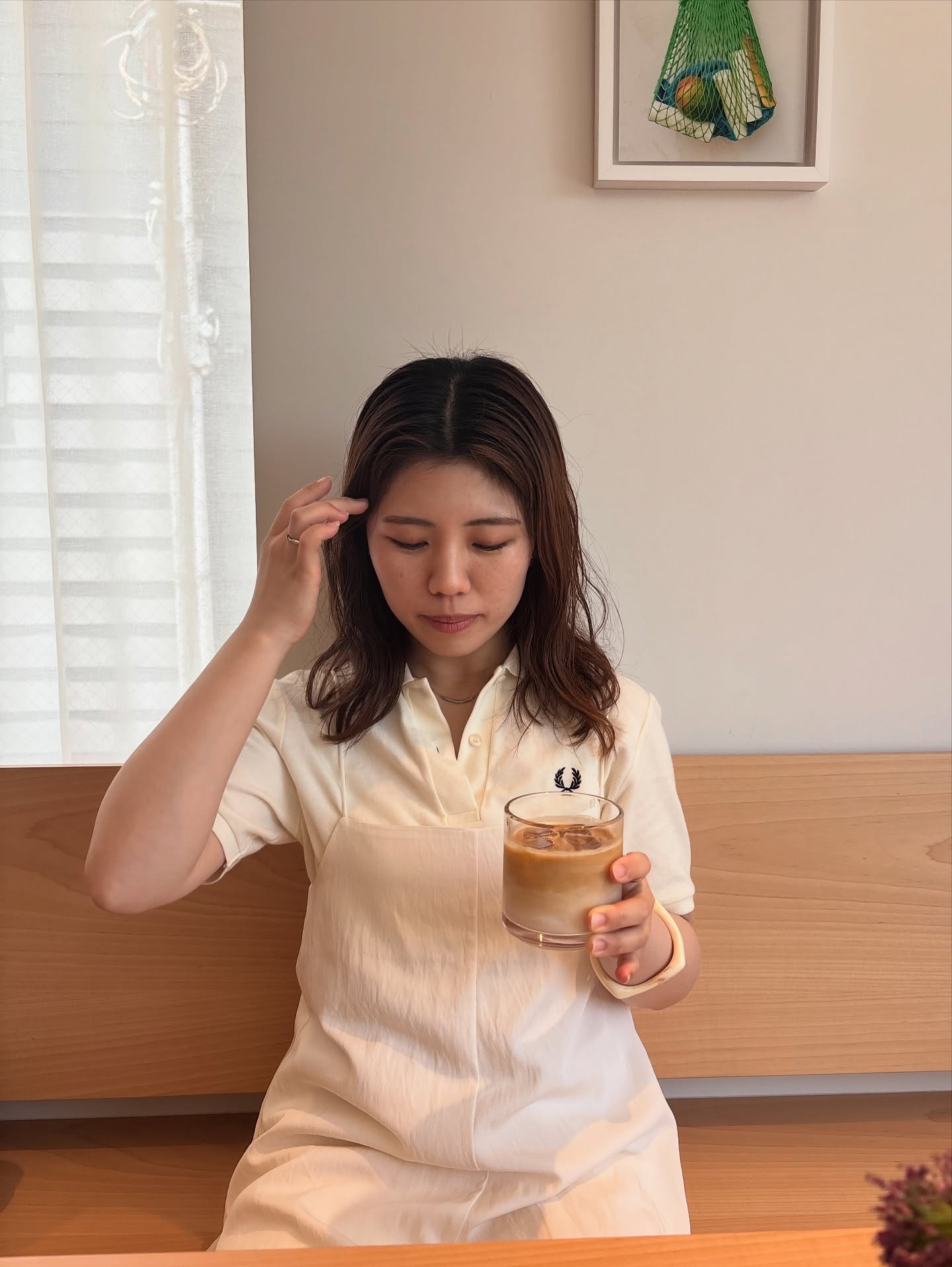 カフェでアイスコーヒーを楽しむ女性のネックレス着用イメージ｜シンプルで上品な首元