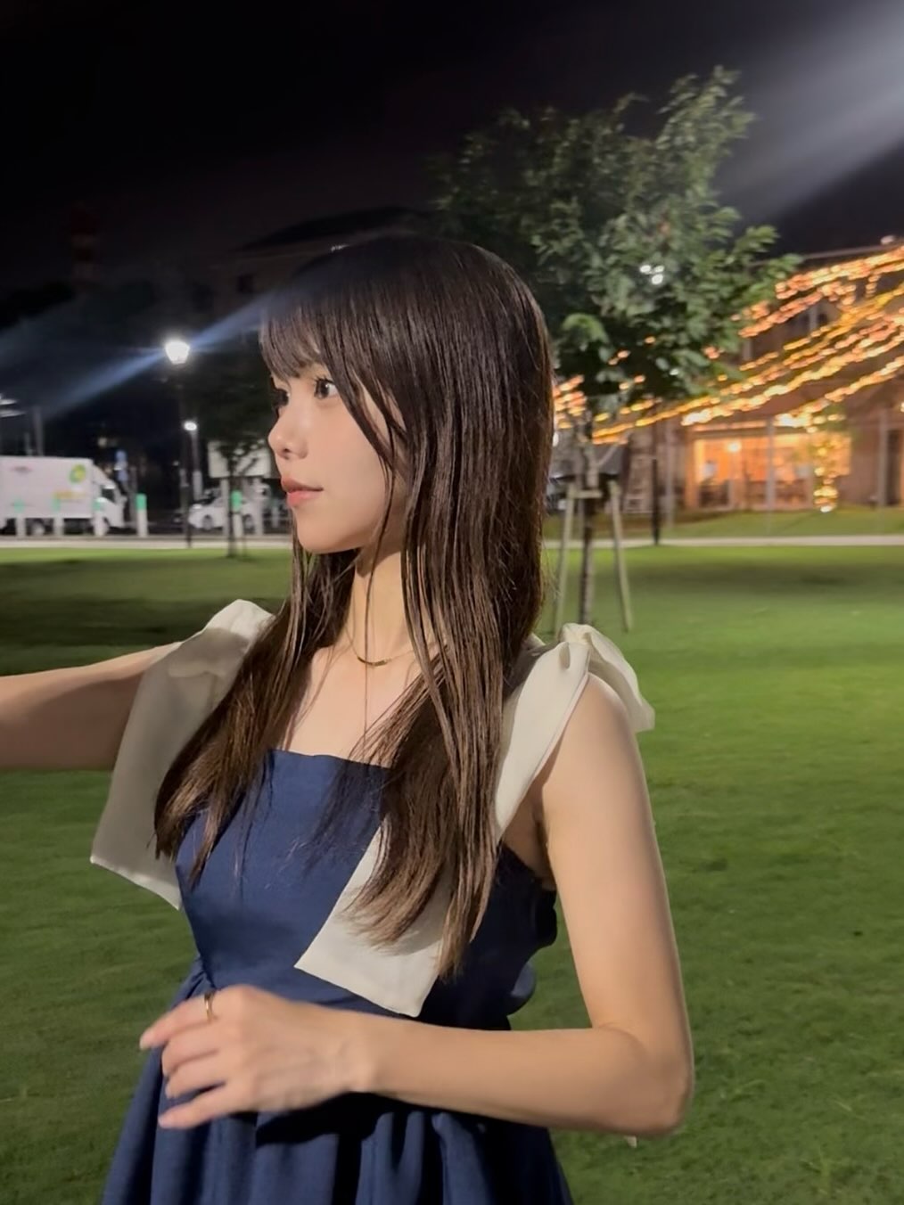 ゴールドのニュアンスリングとネックレスが映える、上品なネイビーワンピースの手元アップ