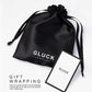 GLUCK(グルック)のロゴ入り黒いサテン製ギフトラッピング用巾着袋とショップカード