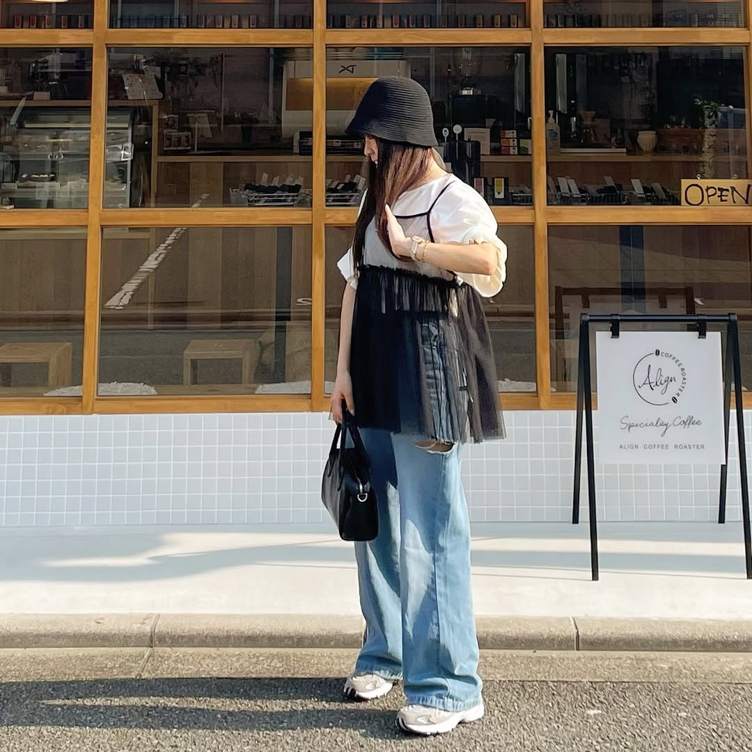 カフェ前でチュールトップスとデニムを合わせ、ブレスレットが映えるカジュアルコーデ